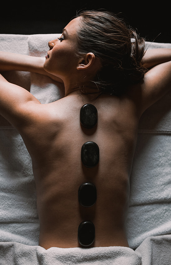 Frau am Rücken liegend bei Hot Stone Massage